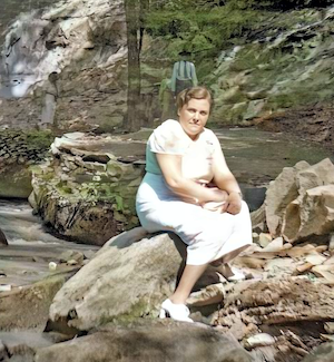 Freda Dumes, sitting on rocks<br>